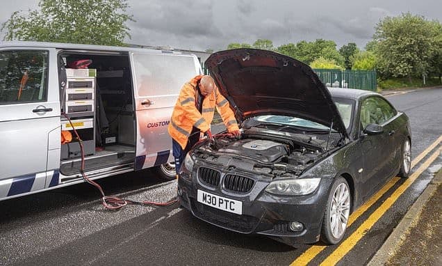 A roadside recovery technician assisting a broken-down vehicle
